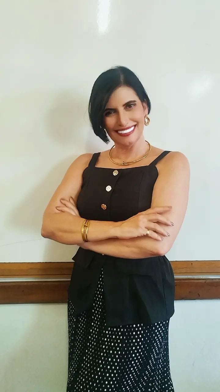 Retrato de Claudia Turatti, sorrindo, de braços cruzados