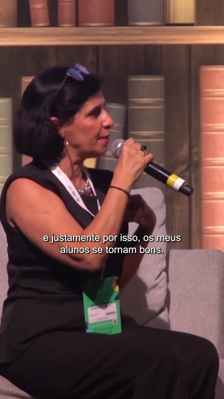 Claudia Turatti ao microfone, em close, durante sua fala no festival